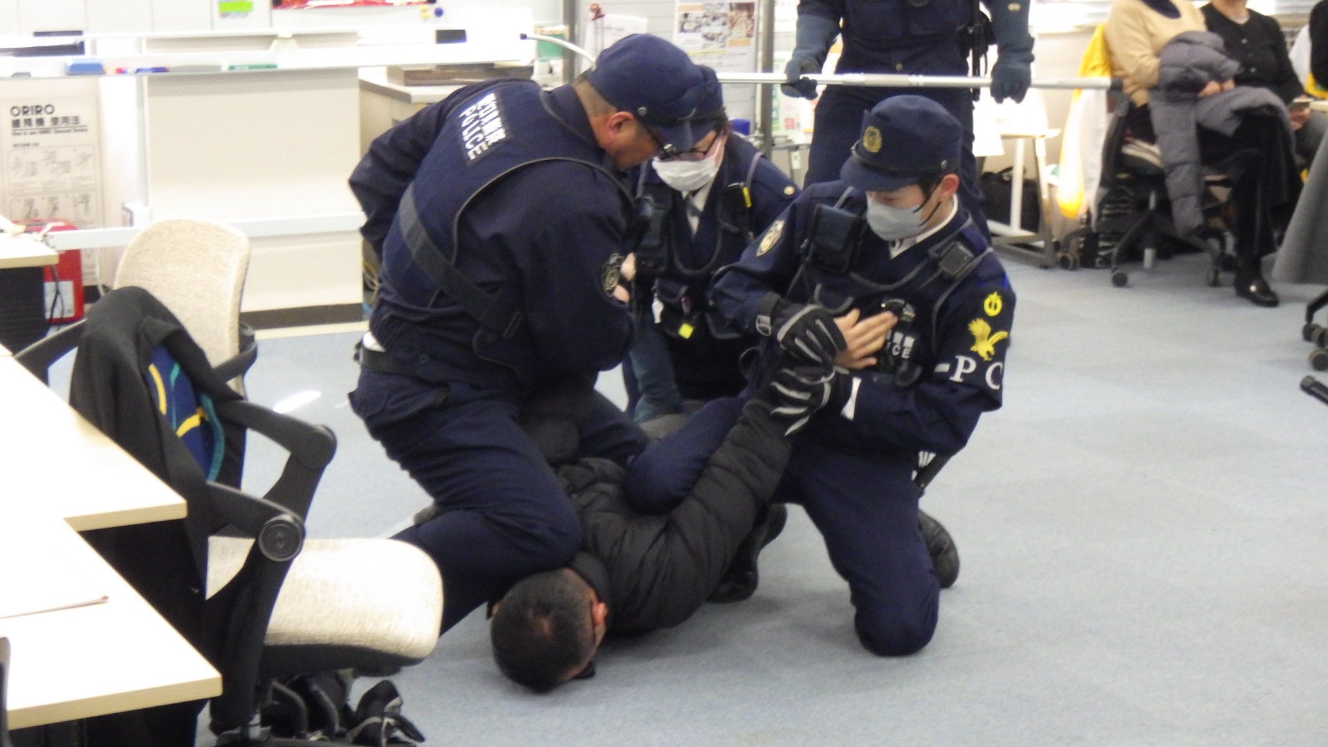 男を取り押さえている状況です。