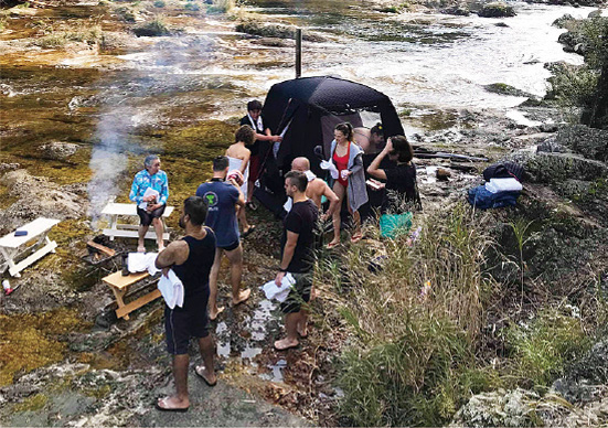 キャンプ場でバーベキューをする家族の写真