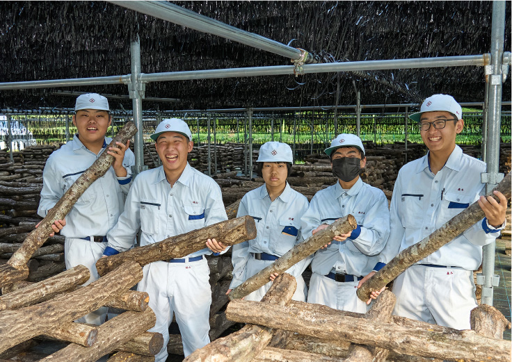 栽培用の木を抱える生徒