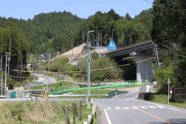 小松地区の様子。右側に橋が見え、現道は左へカーブする。