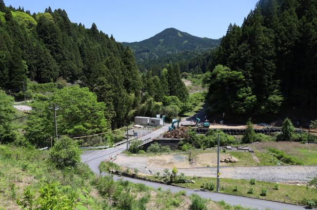 ウバヒガンザクラから東側を見た様子。富士山型の知生山を背に家々の跡が工事現場になっている様子が見える。