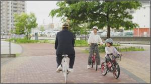 ヘルメットをかぶって自転車に乗った親子が、自転車に乗る松平健さんを発見します