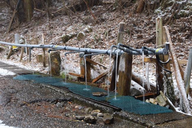 湧き水が塩化ビニル管で配水されている様子