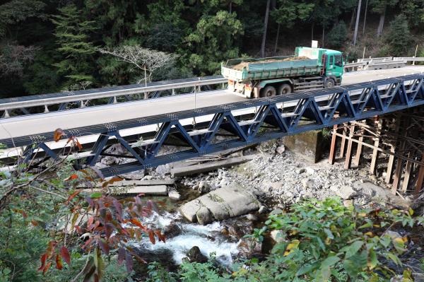 川の中に横倒しになったコンクリートと工事用道路